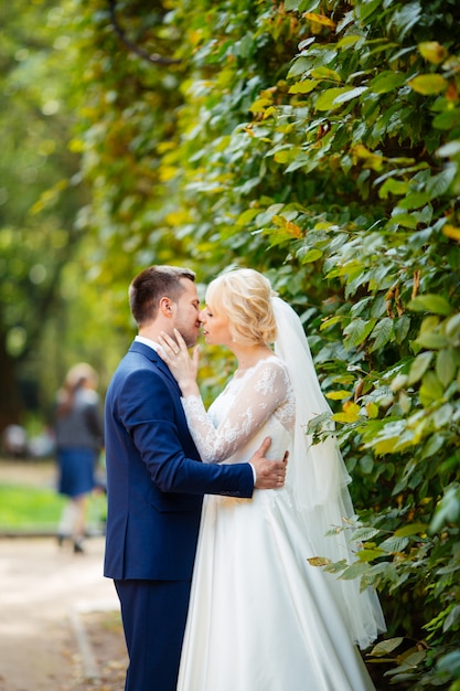 Glückliches Hochzeitspaar, das im Park geht