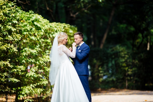 Glückliches Hochzeitspaar, das im Park geht