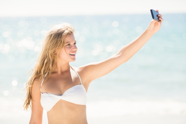 Glückliches hübsches blondes Nehmen selfie