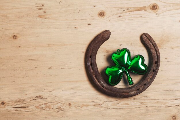 Glückliches Hufeisen mit grünen Kleedekorationen zum St. Patrick's Day