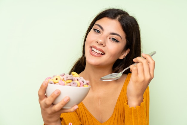 Glückliches Jugendlichmädchen, das mit Schüssel Getreide frühstückt