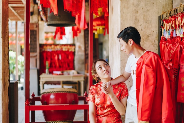 Glückliches junges asiatisches Paar in traditionellen chinesischen Kleidern