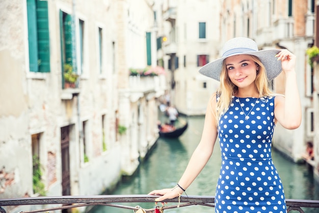 Glückliches junges attraktives Frauenmode-Modell von Venedig Italien in der blauen Tupfenausstattung.