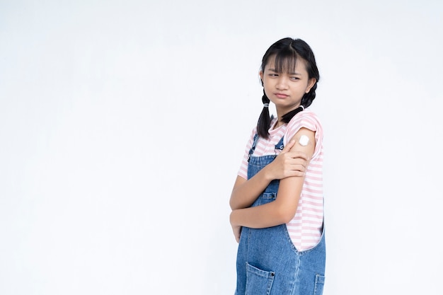 Glückliches junges Mädchen nach der Impfung asiatisches Mädchen auf weißem Hintergrundstudentenmedizinischem Konzept