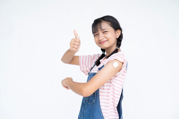 Glückliches junges Mädchen nach der Impfung asiatisches Mädchen auf weißem Hintergrundstudentenmedizinischem Konzept