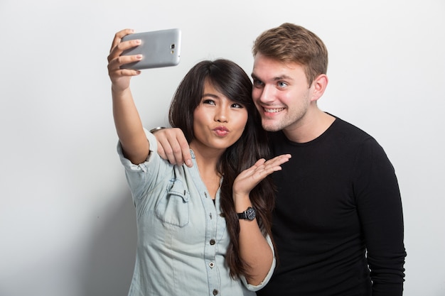 Glückliches junges Multikultur-Paar, das Selbstkamera zusammen nimmt