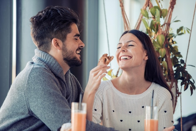 Glückliches junges Paar beim Frühstück im Café