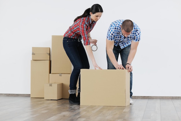 Glückliches junges Paar, das in neues Haus einzieht