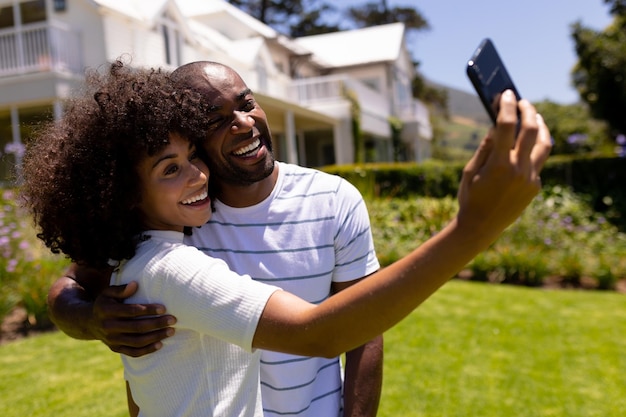 Glückliches junges Paar, das Selfie im Garten macht
