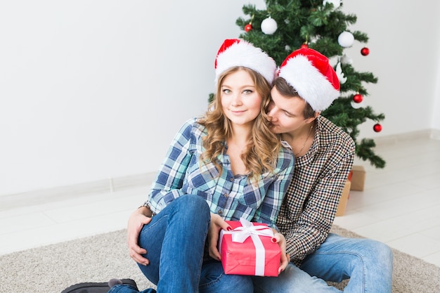 Glückliches junges Paar, das Weihnachten zu Hause feiert.