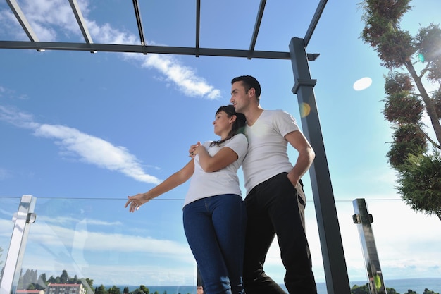 glückliches junges Paar entspannen auf dem Balkon im Freien mit Meer und blauem Himmel im Hintergrund
