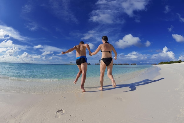 Glückliches junges Paar hat Spaß und entspannt sich im Sommerurlaub vor dem Reiseziel Malediven und dem wunderschönen weißen Sandstrand