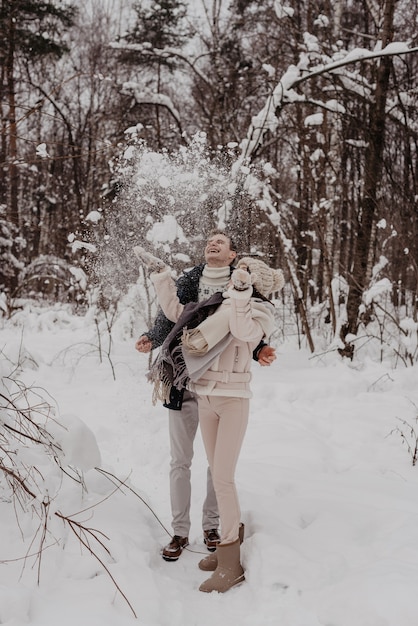 Glückliches junges Paar im Winterpark, das Spaß hat. Familie im Freien. Liebe.