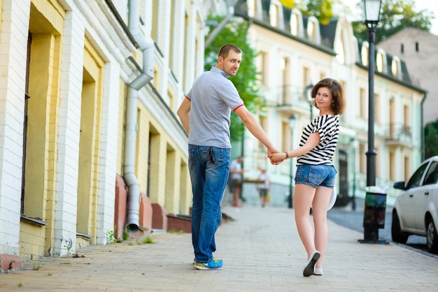 Glückliches junges Paar in der Liebe, die in der Stadt aufwirft