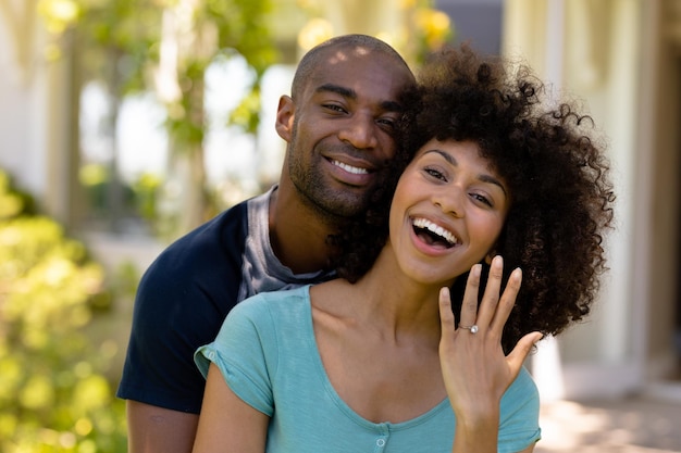 Glückliches junges Paar mit Frau, die ihren Ehering zeigt