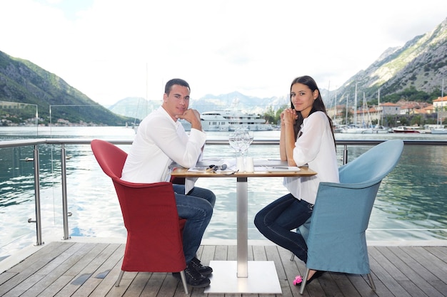 glückliches junges Paar mit Lanch in einem schönen Restaurant am Meer am Strand