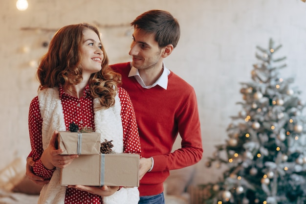 Glückliches junges Paar mit Weihnachtsgeschenken