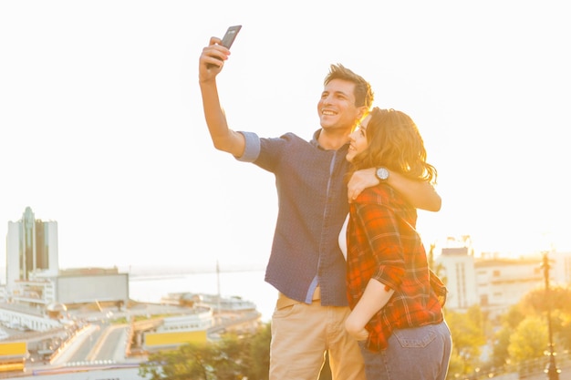 Glückliches junges Paar verliebt in die Stadt an einem sonnigen Sommertag, der Selfie macht. Sommerferien. Liebe Konzept.