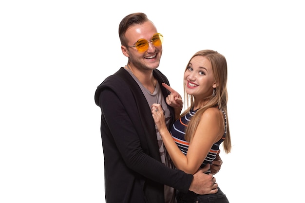 Glückliches junges schönes Paar, das zusammen steht und Studioaufnahme über weißem Hintergrund lacht