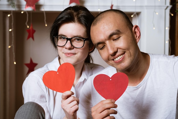 Glückliches junges verliebtes Paar hält rotes Herz in der Hand weicher Fokus