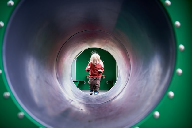 Glückliches Kind, das am Spielplatz spielt