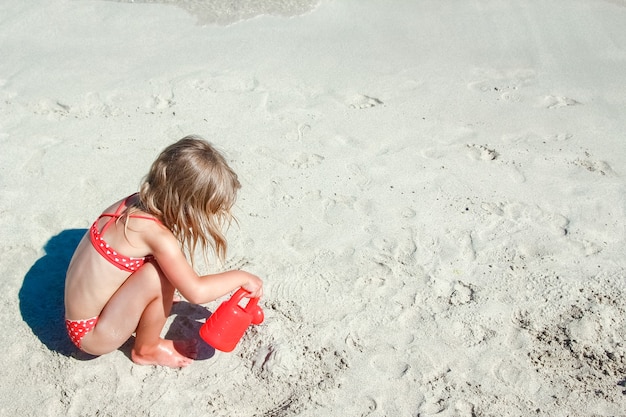 Glückliches Kind, das draußen am Meer spielt