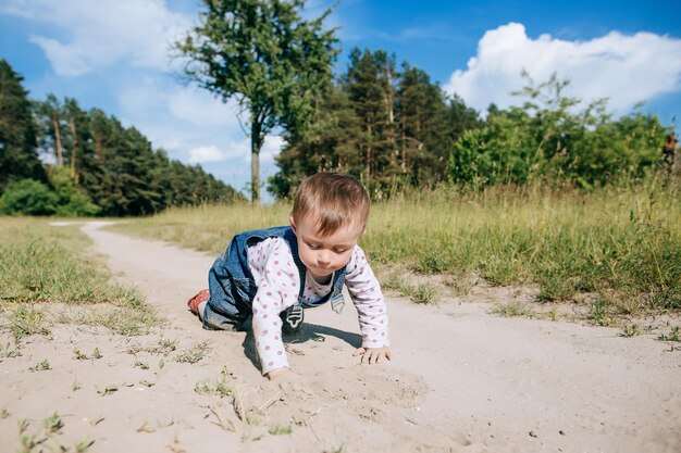 Glückliches Kind, das draußen mit Sand spielt