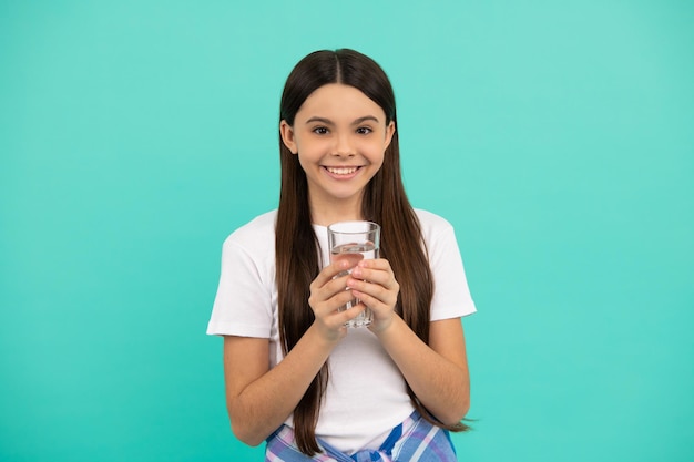 Glückliches Kind, das ein Glas Wasser trinken wird, um hydratisiert zu bleiben und den täglichen Wasserhaushalt im Körper zu halten, Durst.