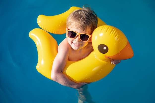 Glückliches Kind, das im Pool schwimmt