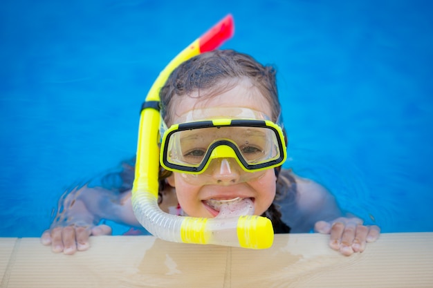 Glückliches Kind, das im Schwimmbad spielt