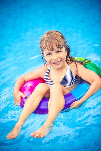 Glückliches Kind, das im Schwimmbad spielt