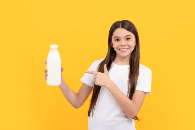 Glückliches Kind, das mit dem Finger auf Milchgetränkeprodukte zeigt Teenager-Mädchen wird Milch trinken