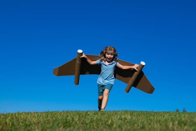 Glückliches Kind, das mit Spielzeug-Jetpack-Kinderpiloten spielt, der Spaß im Freien hat, Erfolg, Kinderinnovation und Leade