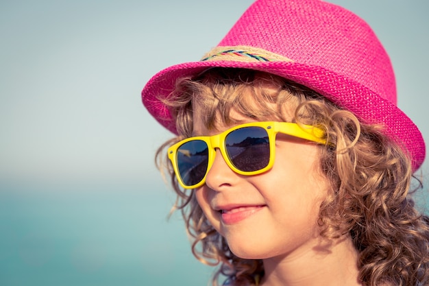 Glückliches Kind gegen Meer und Himmel Sommerferien- und Reisekonzept