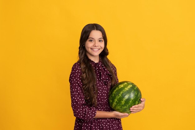 Glückliches Kind hält Wassermelone Wassermelone auf gelbem Hintergrund Kind mit Obst