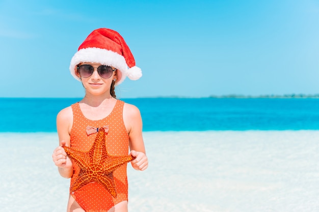 Glückliches Kind in den Weihnachtsferien am Strand