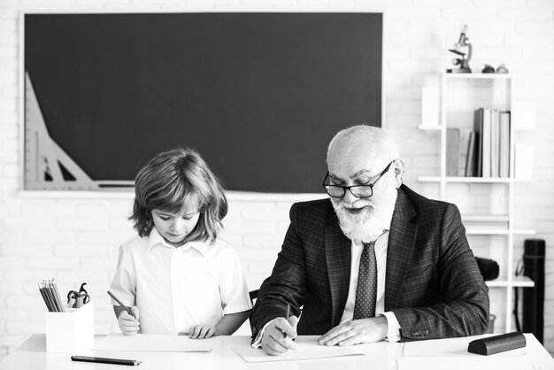 Glückliches Kind in der Schule. Lehrer helfen beim Lernen. Bildung, Unterricht, Grundschule