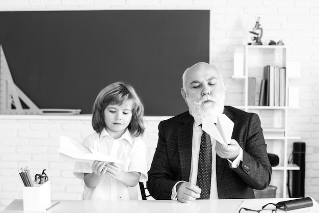 Glückliches Kind in der Schule. Lehrer helfen, Schüler zu lernen. Erziehung, Unterricht, Grundschule.