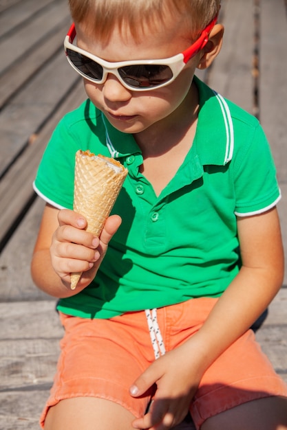 Glückliches Kind in Sonnenbrille mit Eistüte