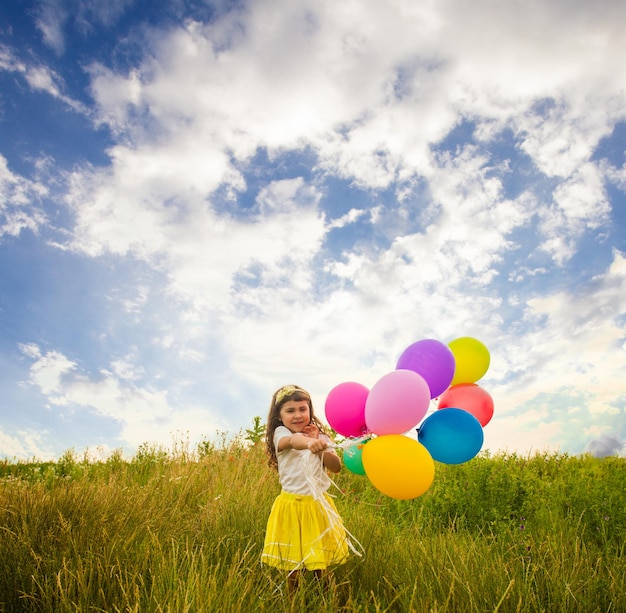 Glückliches Kind mit bunten Spielzeugballons im Freien