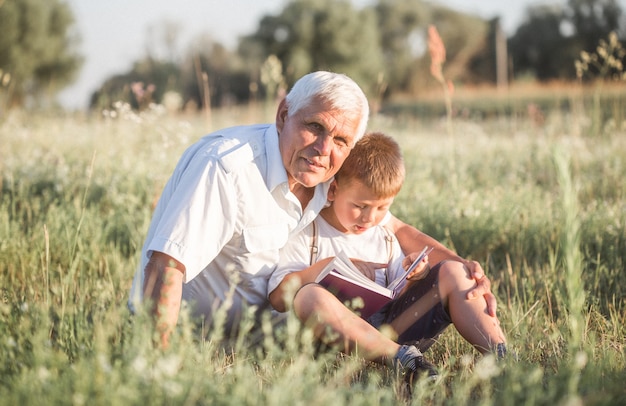 Glückliches Kind mit Großvater, der auf der Wiese spielt