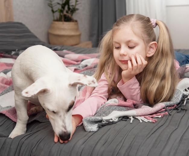 Glückliches Kind mit Hund. Porträtmädchen mit Haustier. Mädchen und weißer Jack Russell