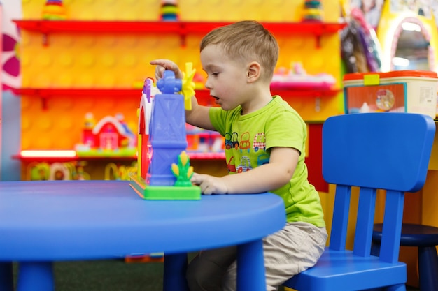 Glückliches Kind mit interessantem Spielzeug im Vorschul- und Kindergartenjunge spielt mit einem bunten Spielzeug