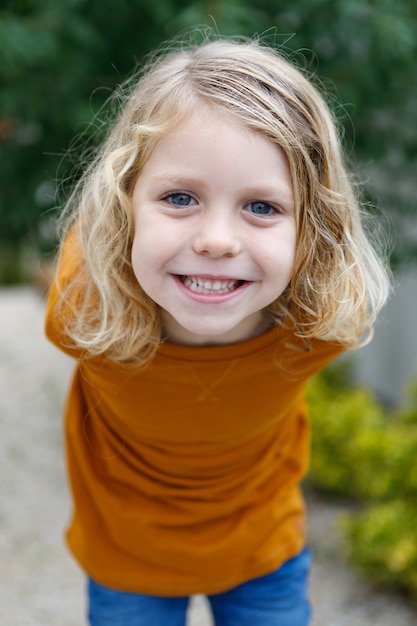 Glückliches Kind mit rotem T-Shirt im Garten