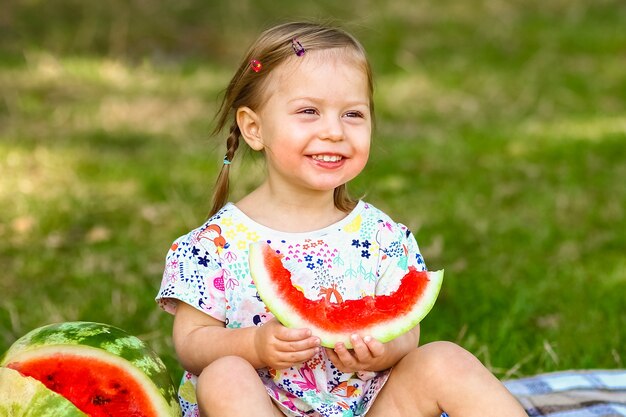 Glückliches Kind mit Wassermelone auf Natur im Park