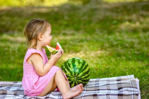 Glückliches Kind mit Wassermelone in der Natur