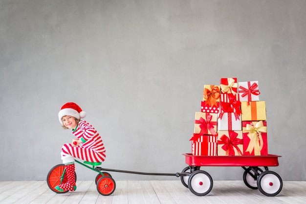 Glückliches Kind mit Weihnachtsgeschenk. Kind hat Spaß zu Hause