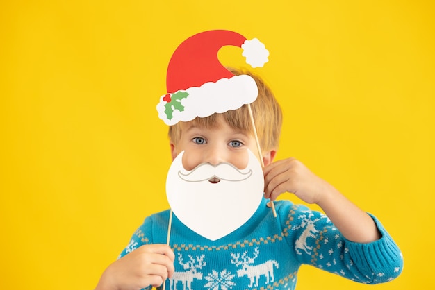 Glückliches Kind mit Weihnachtsmann-Hut und Bart