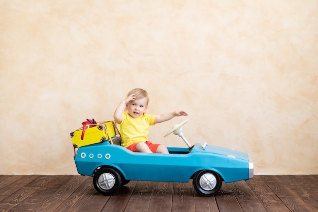 Glückliches Kind reitet Spielzeug Vintage Auto