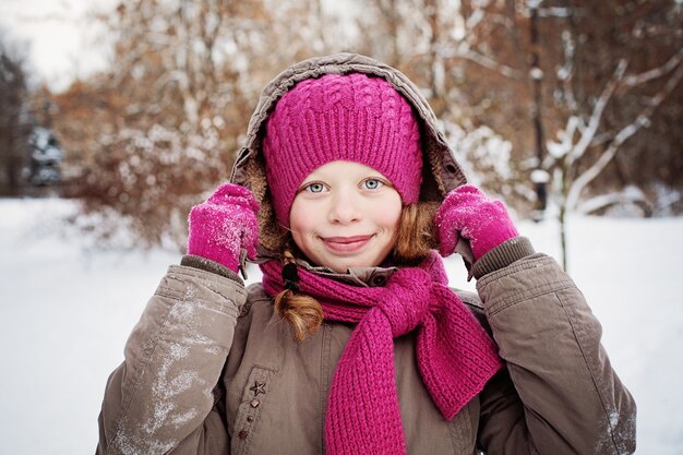 Glückliches Kindermädchen im Wintertag im Freien